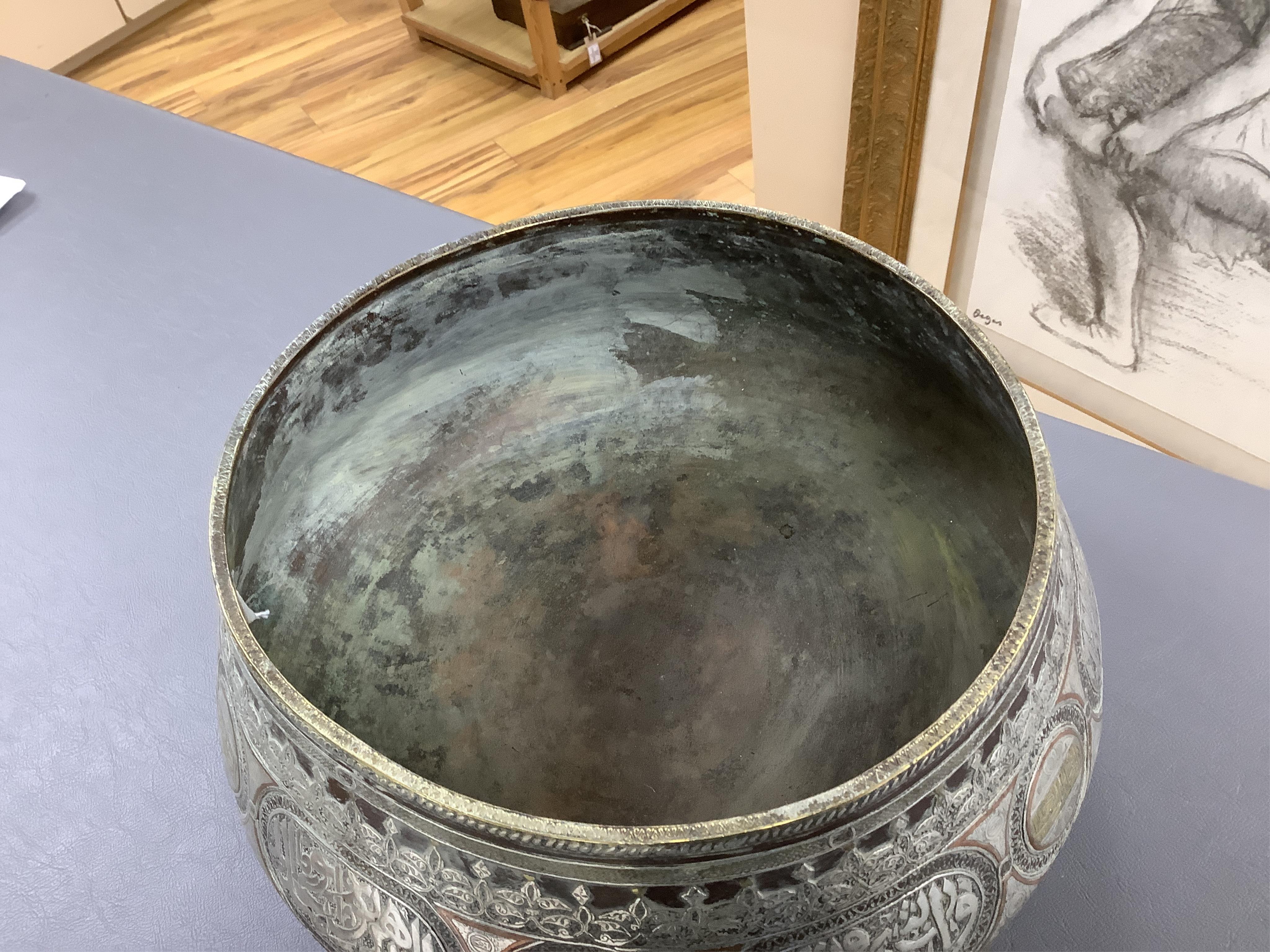 A late 19th century Mamluk style brass basin inlaid with silver and copper decoration, 29cm diameter